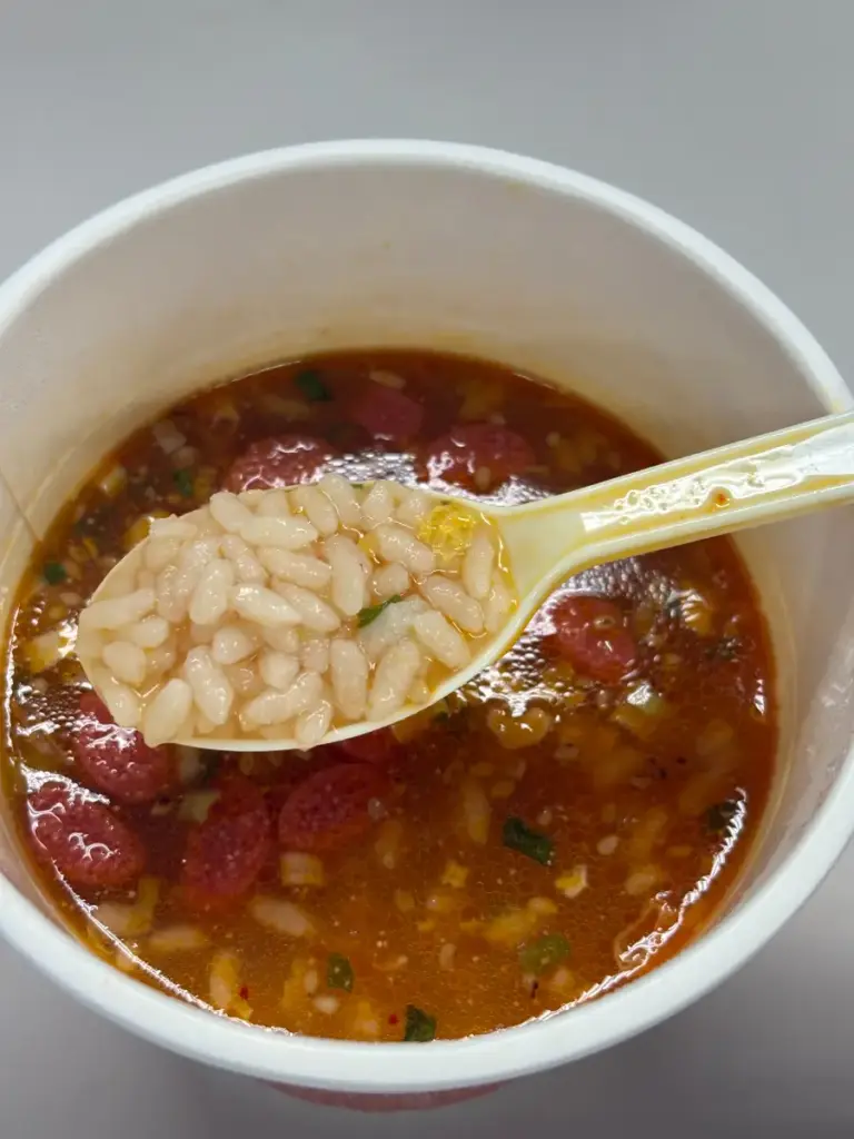 レンゲですくった日清だし茶づけ明太子のご飯。スープと米粒が絡んでいる。