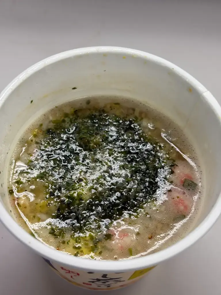 日清だし茶づけ鯛だしにお湯を注いだ後の完成形。表面にあおさが広がり、金色のだしが輝く