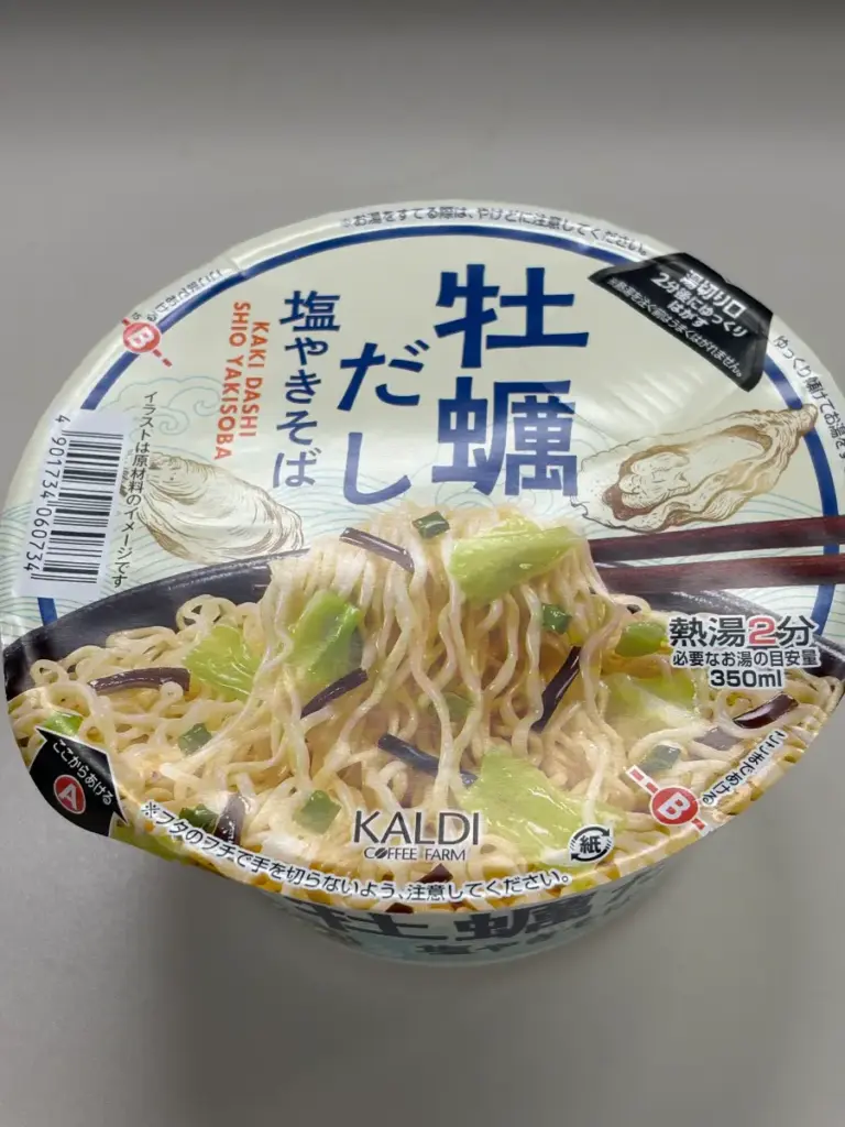 KALDI 限定カップ麺「牡蠣だし塩やきそば」のパッケージ写真。フタに牡蠣のイラストと商品名が大きく記載され、必要なお湯の目安350mlと熱湯2分調理の表記がある。レビュー・口コミ記事用。