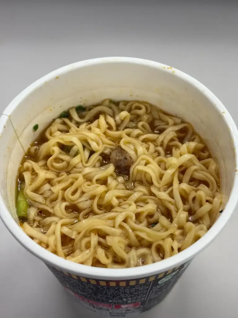 魔改造カップヌードル もつ鍋しょうゆ味のスープ表面。背脂やニラが浮かび濃厚さを演出。