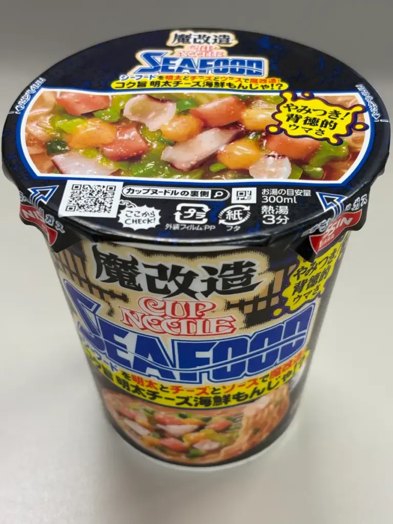 魔改造カップヌードル シーフードの黒いパッケージとフタ、カラフルな具材写真入りデザイン